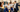 Man in a suit showing factory workers something on a whiteboard